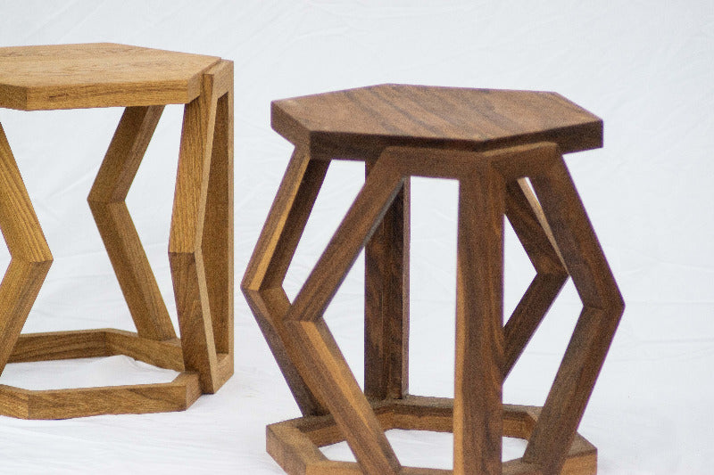 Two wooden stools with geometric designs on a white background
